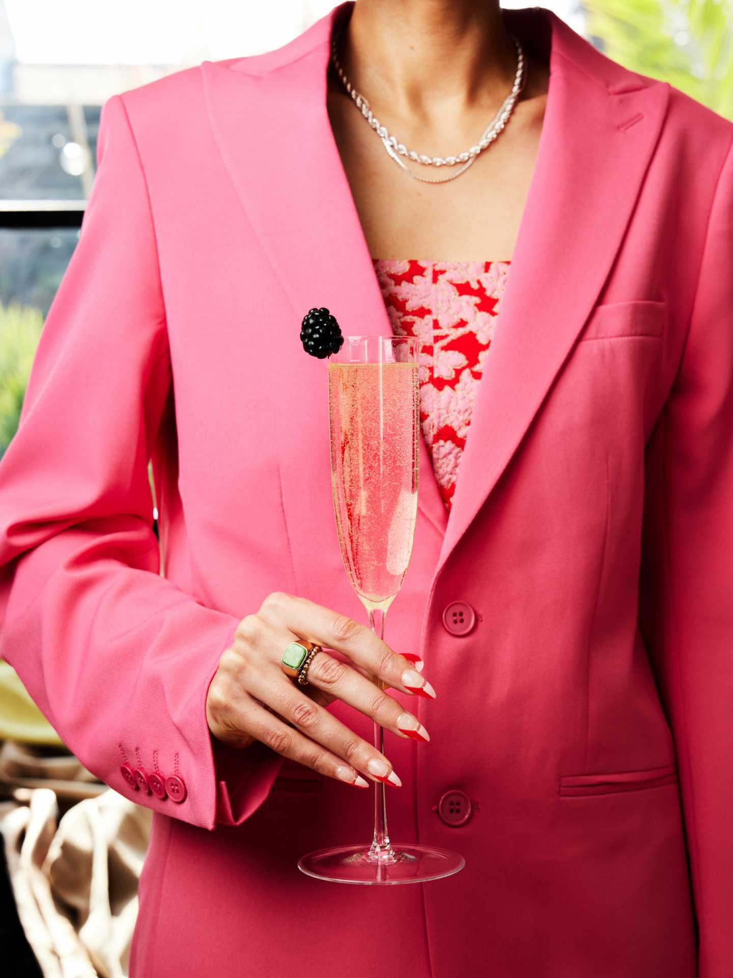 A lady in pink holds a cocktail made with St-Germain Elderflower Liqueur