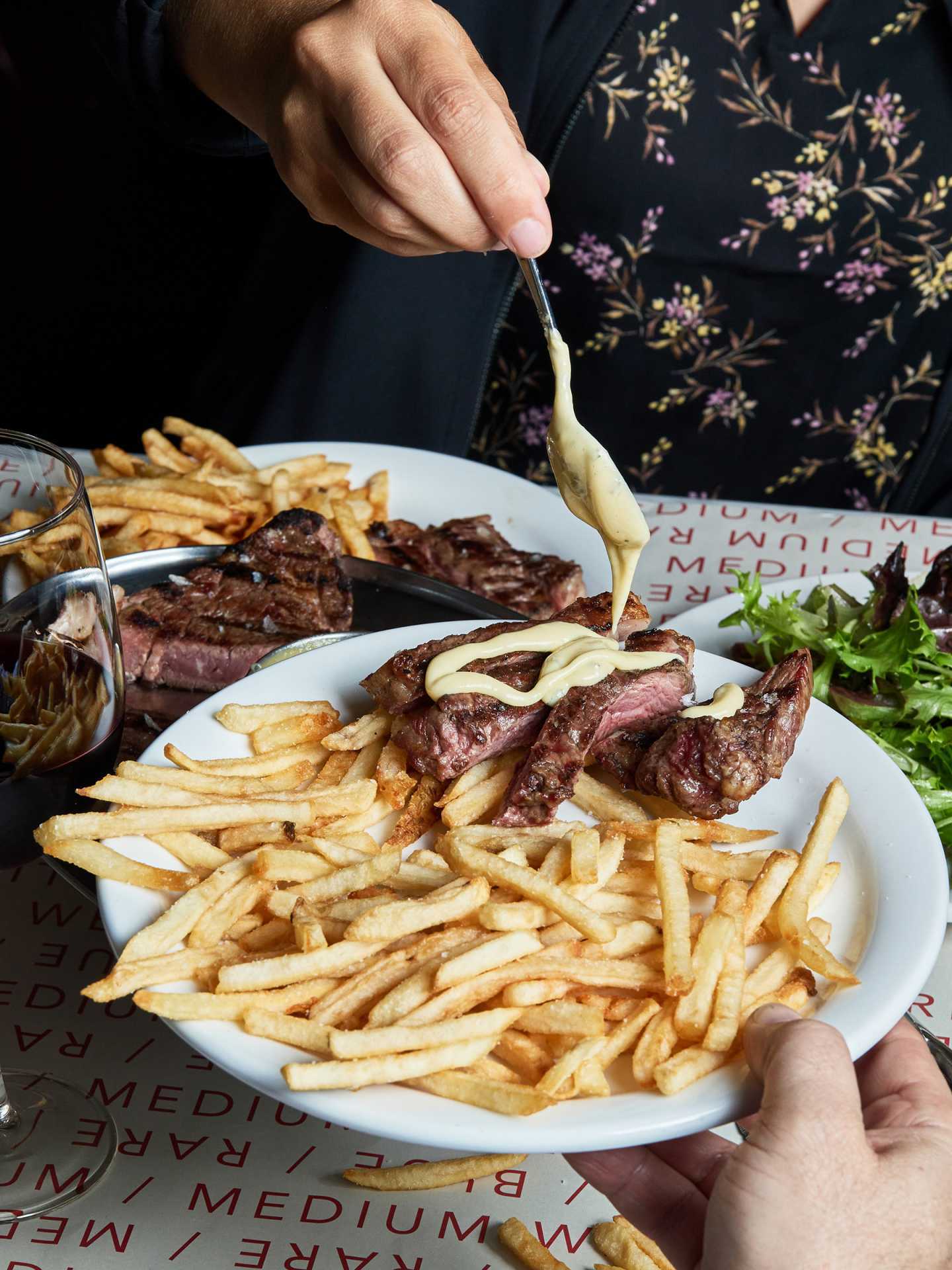 Best new Toronto restaurants | Drizzling sauce on steak with frites at J's Steak Frites