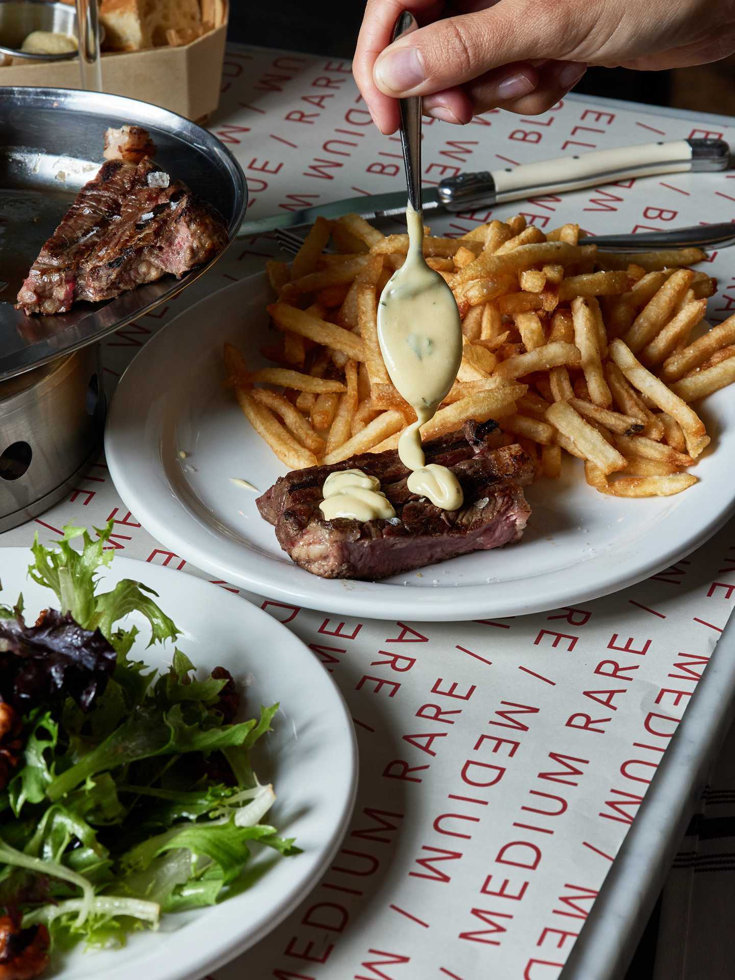 Best new Toronto restaurants | A plate of steak at J's Steak Frites topped with sauce