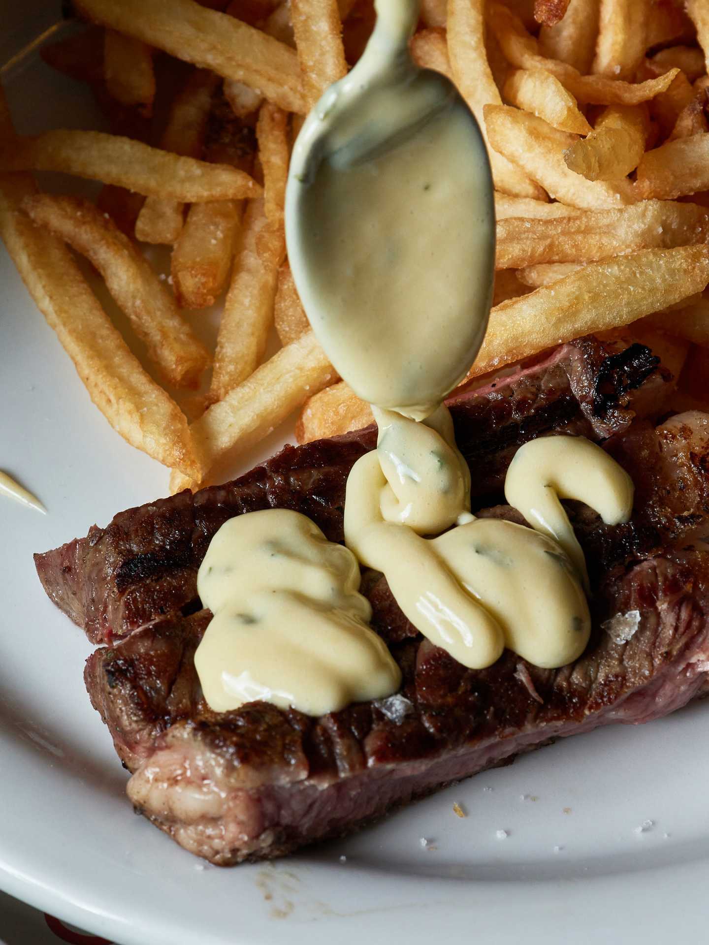 Best new Toronto restaurants | Drizzling sauce on steak at J's Steak Frites