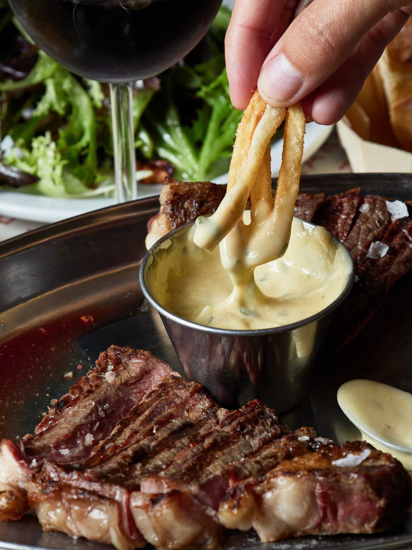 Best new Toronto restaurants | Dipping fries into sauce at J's Steak Frites