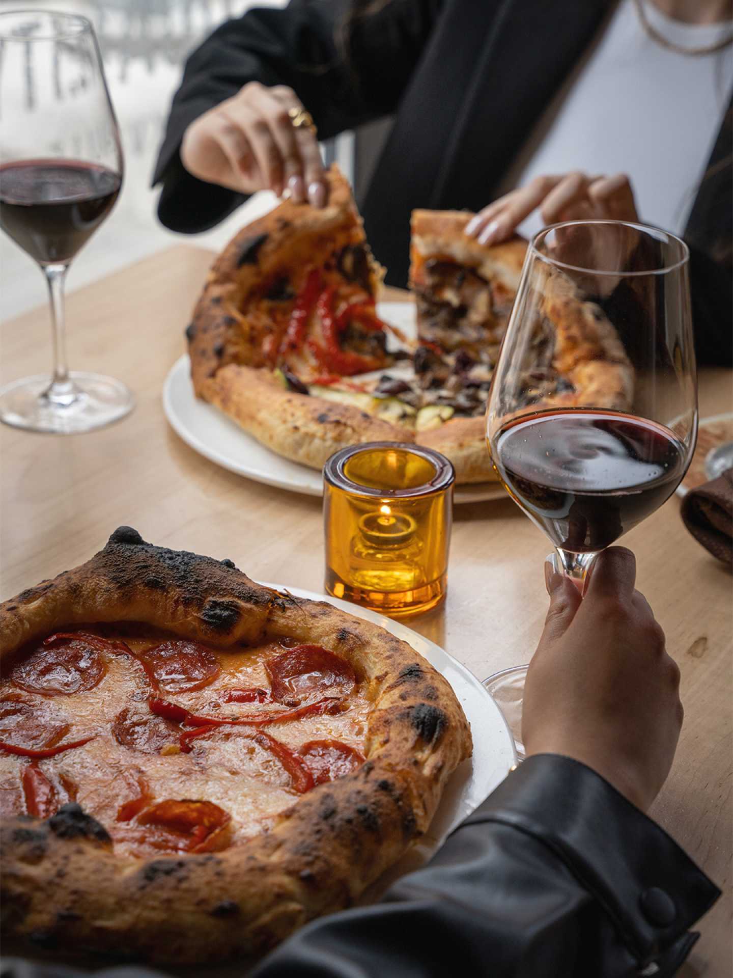 Guests enjoying individual pizzas at Cibo Wine Bar