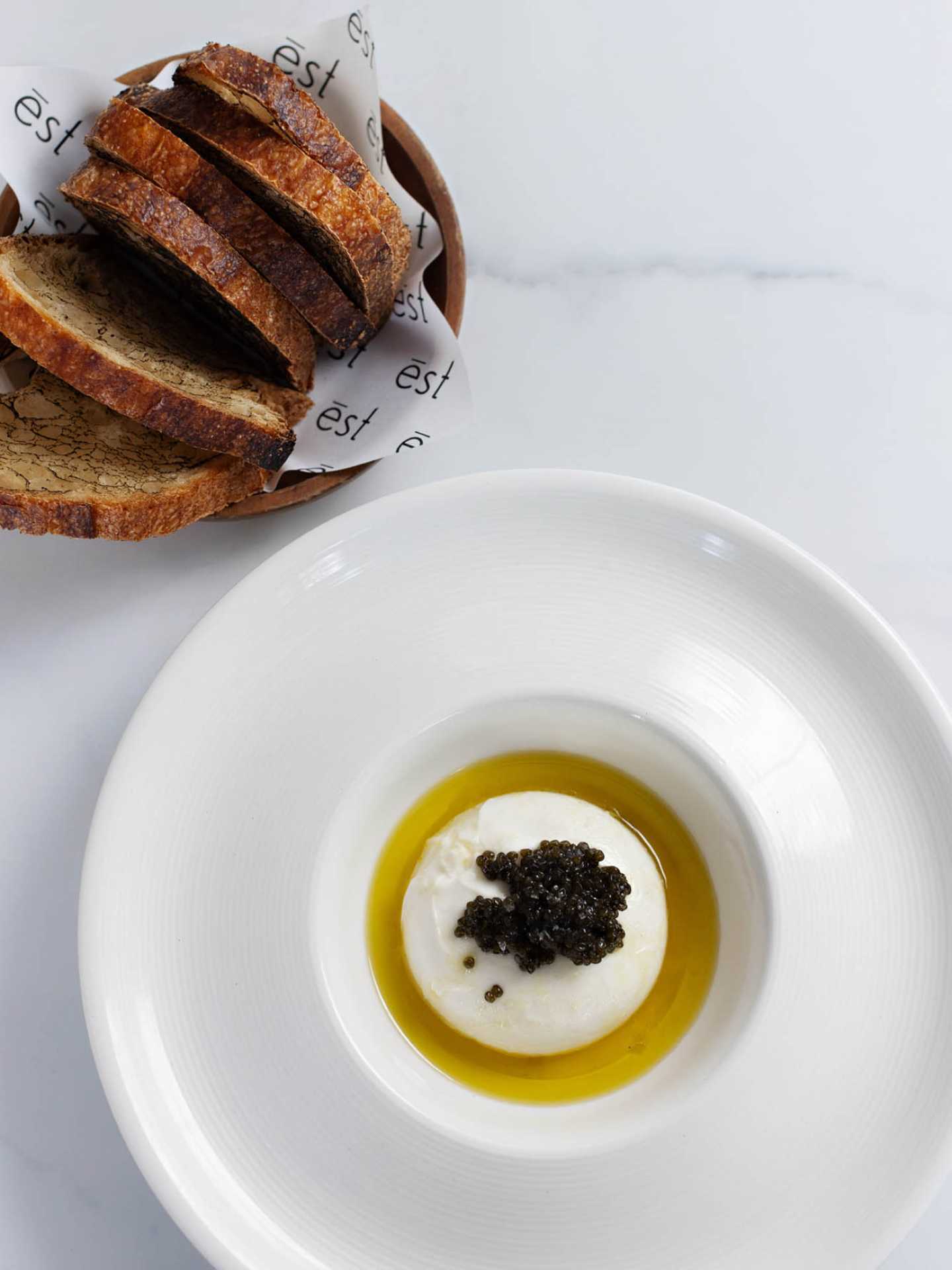 Slices of bread and burrata with caviar at ēst restaurant