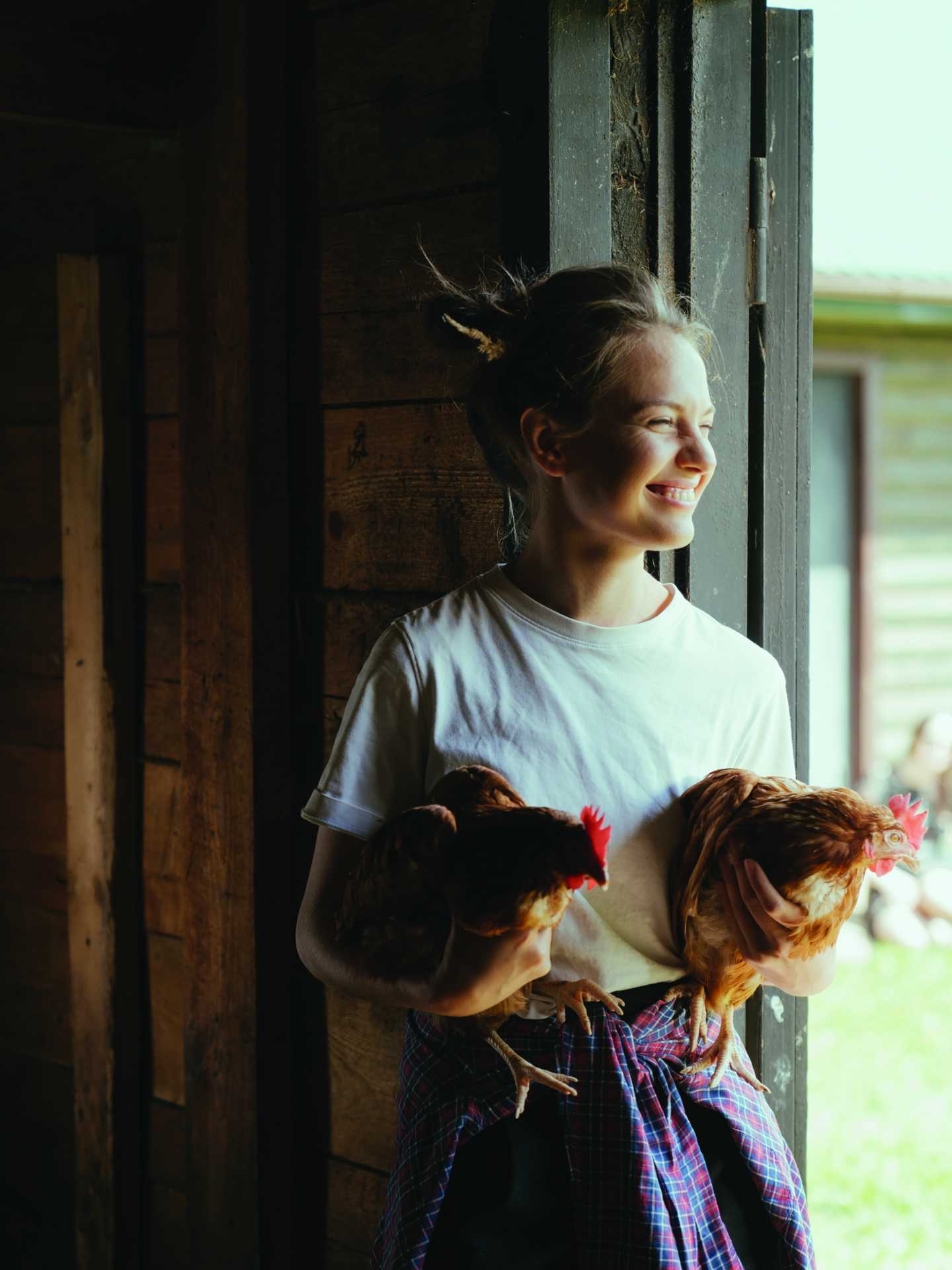 A woman holding two chickens