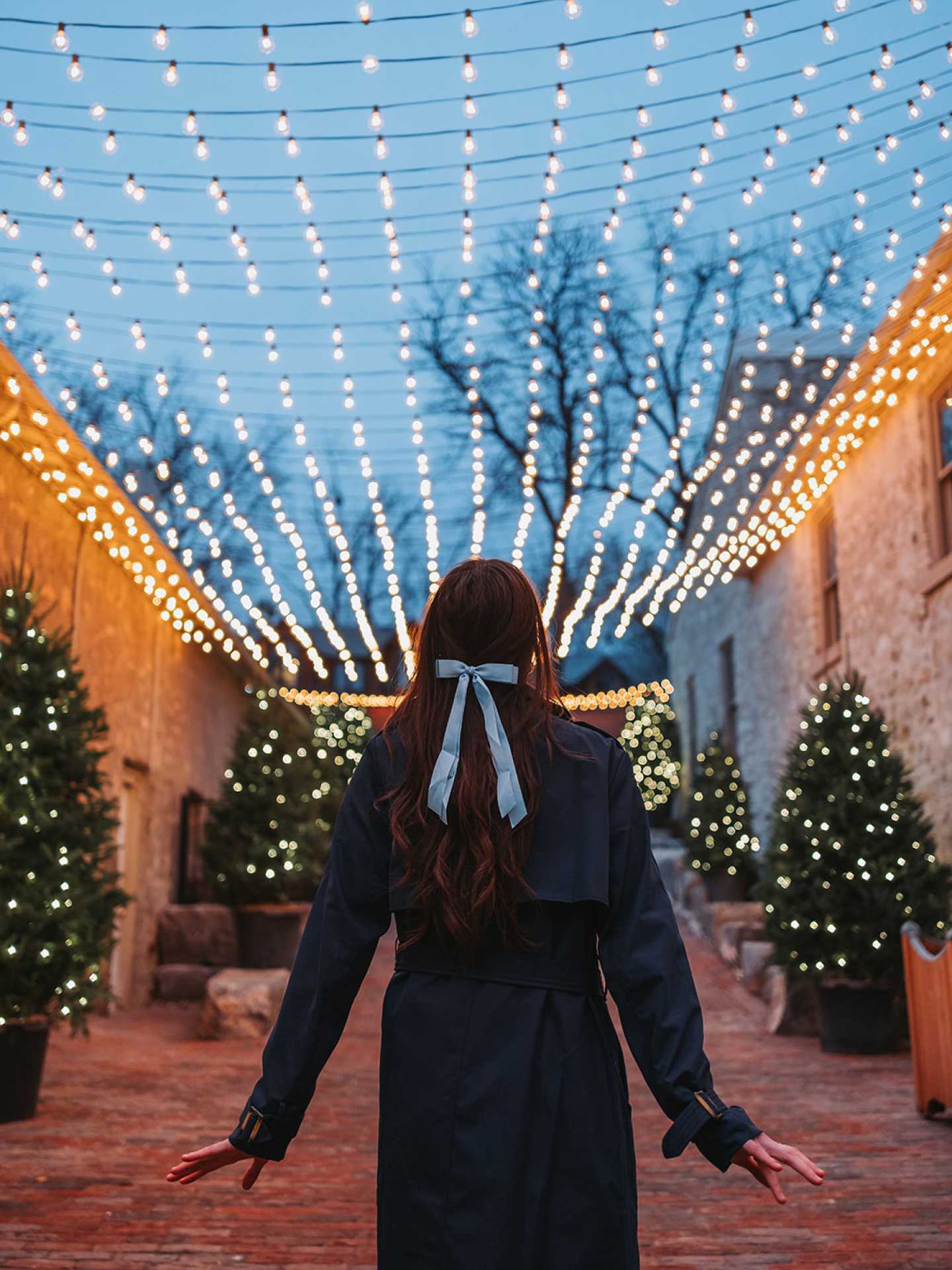 Elora Christmas Market | A woman walks under the twinkling lights at Elora Christmas Market