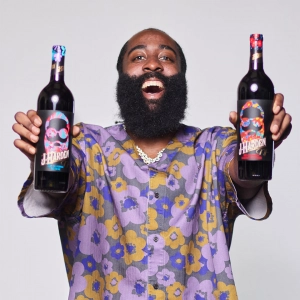 James Harden holding two bottles of red wine