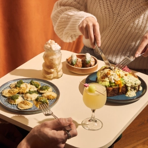 Ravioli, cocktails and avocado toast on a table with cutlery