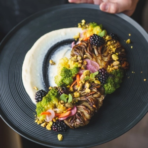 A cauliflower dish served on top of puree with fruits and nuts at GIA restaurant