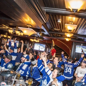 Fans at a bar celebrating the Toronto Maple Leafs scoring a goal