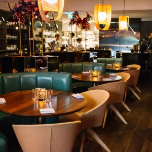 The dining room with green booths at Alobar Yorkville