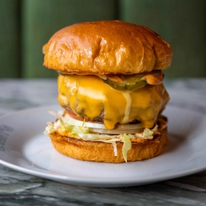 A juicy burger with melted cheese and pickles