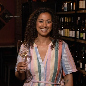 Nabilah Rawji smiling and holding a glass of riesling