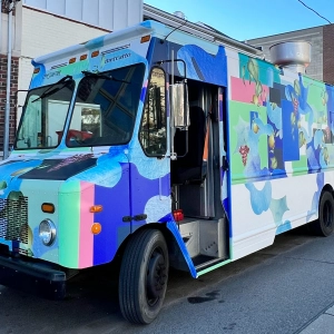 A blue food truck on the road
