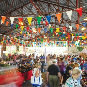 A farmers' market with string flags draped across the ceiling