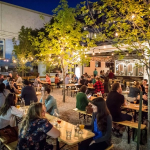 A crowd of guests sitting on a string-light-lined patio at Bandit Brewery