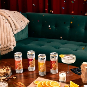Cans of Vizzy Mimosa Hard Seltzer on a coffee table with confetti