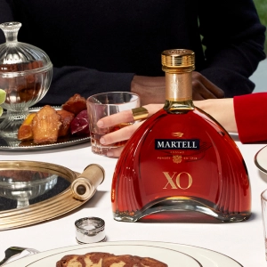 Martell Cordon XO cognac on the dinner table with a couple in the background
