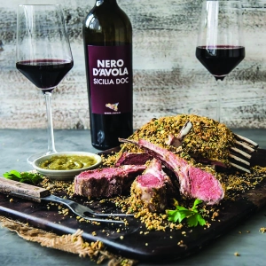 A large cut of crusted meat with a Nero D'Avola Sicilia DOC wine and glass