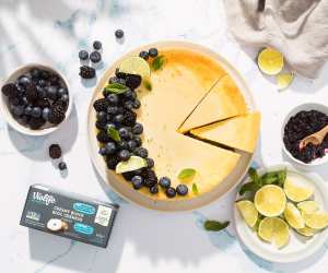 An overhead view of a cheesecake topped with blueberries, and a Violife Creamy Block