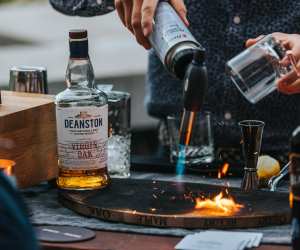 Deanston smoked old fashioned recipe | a bartender using a blow torch on a cocktail smoking board from Spirits with Smoke