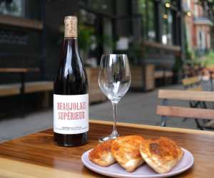 Somm wine app Grand Cru membership | A glass of wine and pastries on the patio