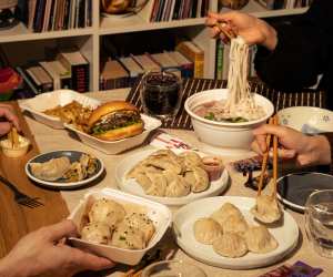 An assortment of cheap eats from different restaurants including noodles, dumplings and a burger