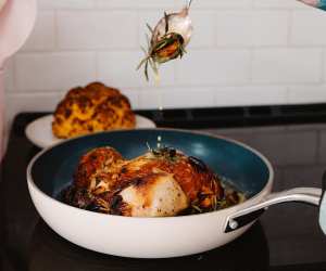 Kilne Everything Pan with a roast chicken in the pan and a cauliflower in the background