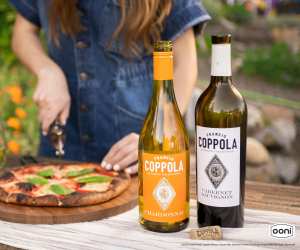 Coppola wines and a woman slicing a freshly baked pizza