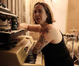 Serena Ryder sitting at her piano with a can of Libra non-alcoholic beer