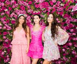 Three people in front of a flower wall at the Rosé Picnic at Hotel X