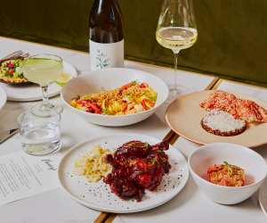 A spread of dishes and wine at Henry's restaurant Toronto